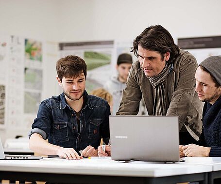 Studierende arbeiten mit Professor